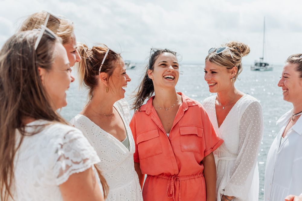 groupe de copines au bord de la mer qui rigolent pendant un evjf