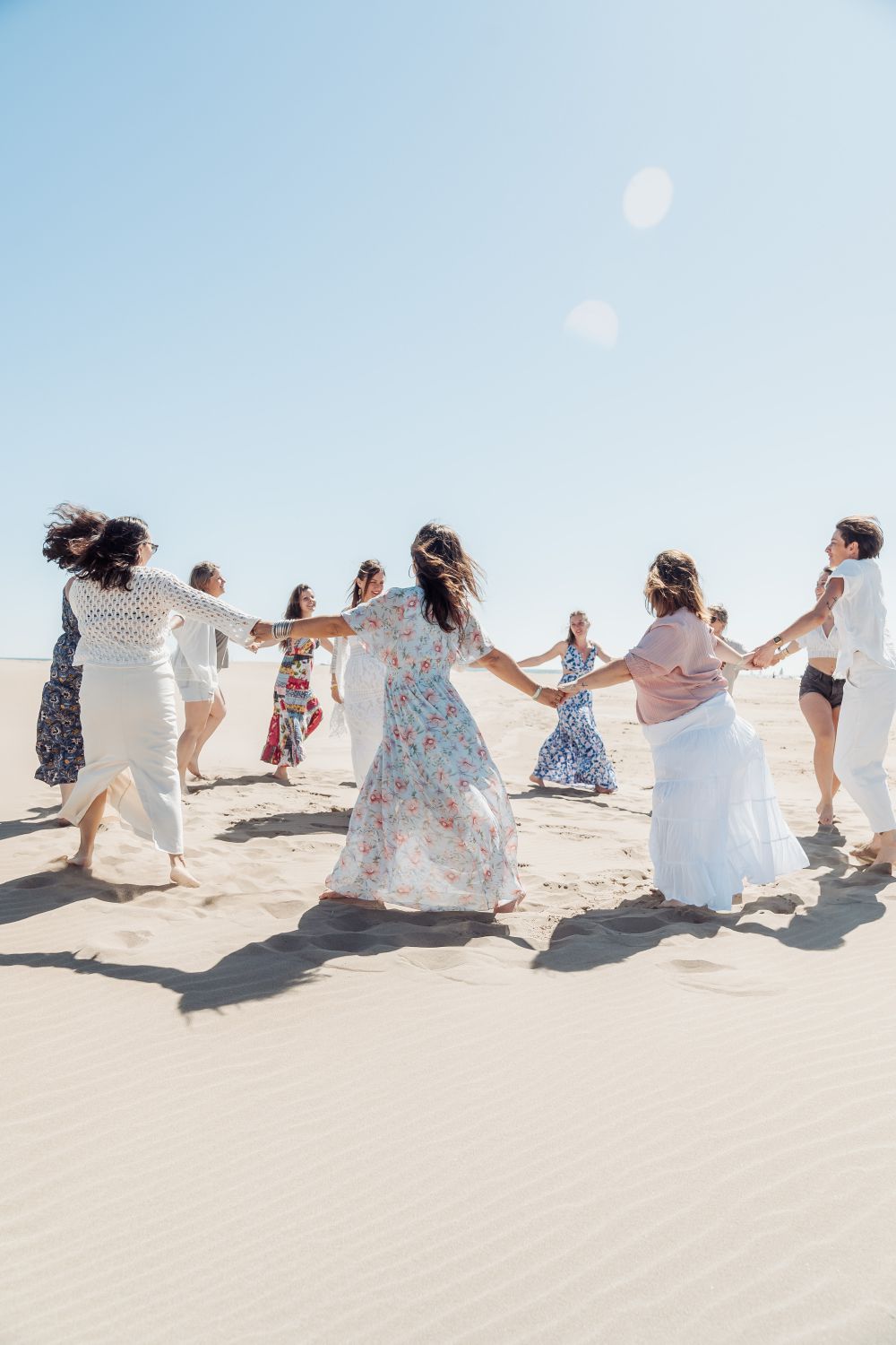 team bride qui se tiennent la main sur la sable pour un shooting photo evjf a marbella